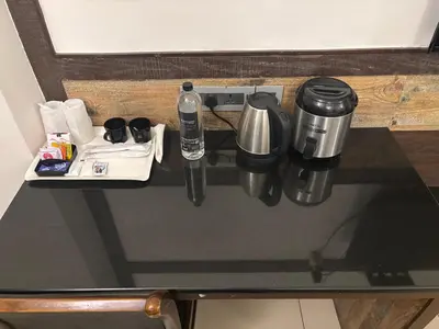 a table with a coffee maker and other items on it at WESTLAND HOTEL- ERODE in Erode