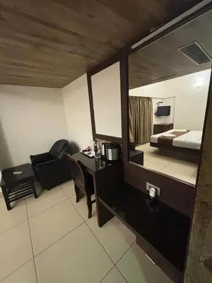 a room with a bed and a table and a mirror at WESTLAND HOTEL- ERODE in Erode