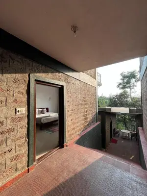 a brick building with a door leading to a bedroom at Red Stone Villas in Madikeri