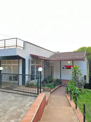 a building with a fence in front of it at Red Stone Villas in Madikeri