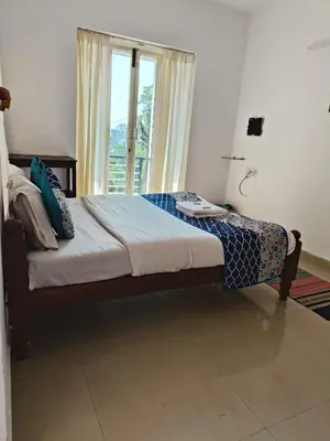 a bed sitting in a bedroom with a window at Red Stone Villas in Madikeri