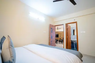 a bedroom with a bed and a mirror at Elegance Serviced Apartment in Mysore