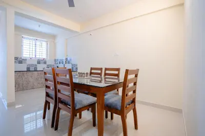 a dining room with a wooden table and chairs at Elegance Serviced Apartment in Mysore