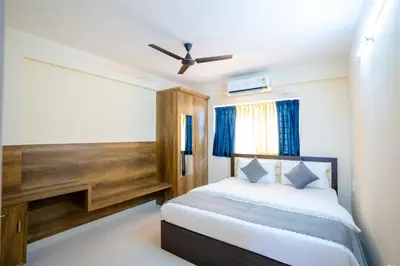a bedroom with a bed and a ceiling fan at Elegance Serviced Apartment in Mysore