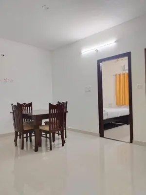 a dining room with a table and chairs and a mirror at ORCHID ELITE BRINDAVAN in Mysore