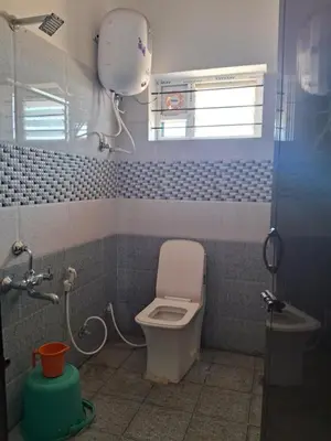 a bathroom with a white toilet and a window at Royal homes a2 in Kushālnagar