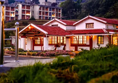 a white house with a red roof at Lauriston Ooty Town Heritage Bungalow by VOYE HOMES in Ooty