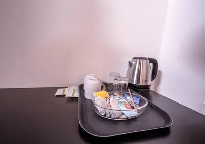 a tray with a coffee maker and a bowl of food at Lauriston Ooty Town Heritage Bungalow by VOYE HOMES in Ooty