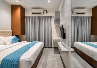 a hotel room with two beds and a tv at J Square Inn in Coimbatore