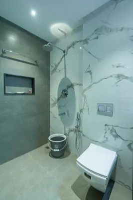 a bathroom with a toilet and a wall at J Square Inn in Coimbatore