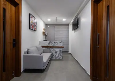 a living room with a couch and a television at J Square Inn in Coimbatore