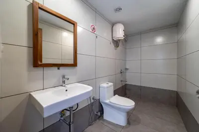 a bathroom with a sink and a toilet and a mirror at WINTEL WILD in Vālpārai