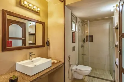 a bathroom with a sink and a toilet and a shower at Mango Hill Shola Ooty in Ooty