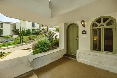 a front porch of a home with a green door at Mango Hill Shola Ooty in Ooty