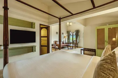 a bedroom with a bed with a television on the wall at Mango Hill Shola Ooty in Ooty