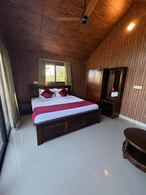 a bedroom with a bed in a wooden room at Ibbanicadu Estate Homestay in Madikeri