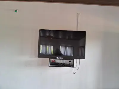 a flat screen tv hanging on a wall at Royal homes a3 in Kushālnagar