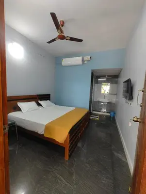 a bedroom with a bed with a ceiling fan at JP Residency, near to Isha, Adhiyogi & Karunya in Alāndurai