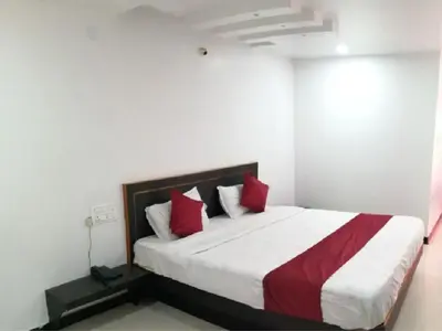 a bedroom with a large bed with red pillows at The Travellers Nest in Ooty