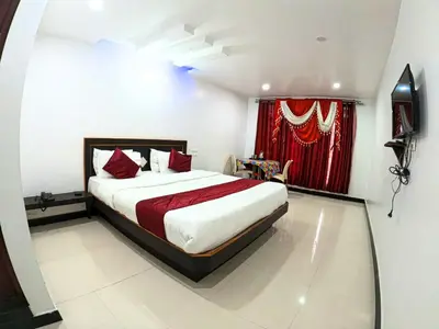 a bedroom with a bed and a red curtain at The Travellers Nest in Ooty