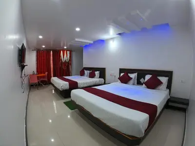 a hotel room with two beds and a television at The Travellers Nest in Ooty