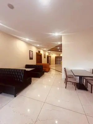 a lobby with couches and a table and chairs at Fortune Hills in Palakkad