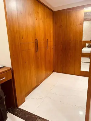 a room with a wooden door and a white floor at Fortune Hills in Palakkad