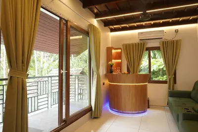 a living room with a couch and a large window at Mangrove Heritage Home, Chendamangalam in Cochin