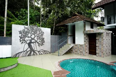 a mural of a tree next to a swimming pool at Mangrove Heritage Home, Chendamangalam in Cochin