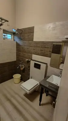 a bathroom with a toilet and a sink at Diya's Estate Stay in Thamarassery