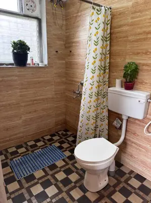 a bathroom with a toilet and a shower curtain at Bagaan - Tea Plantation Stay, Ooty in Aruvankadu