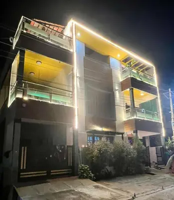 a large apartment building with a parking garage at night at Bhoomiputra Mansion in Mysore