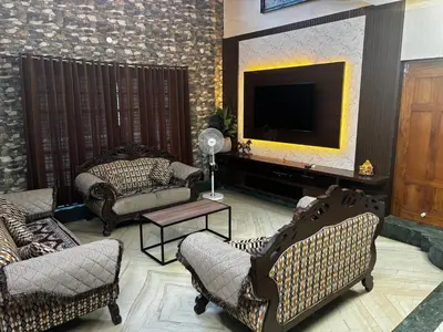 a living room with couches and a flat screen tv at Bhoomiputra Mansion in Mysore