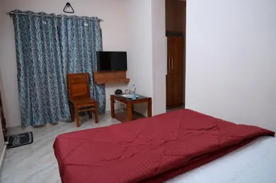 a bedroom with a bed with a red comforter at HILL PALACE RESIDENCY COORG in Virajpet