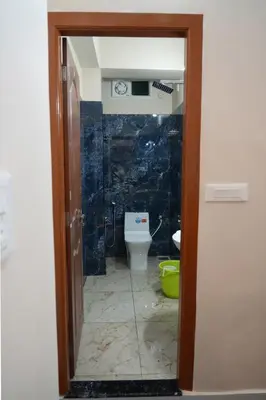 a bathroom with a toilet in a room at HILL PALACE RESIDENCY COORG in Virajpet