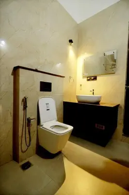 a bathroom with a toilet and a sink at Eazy Homes in Palakkad