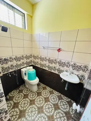 a bathroom with a toilet and a sink at Rivera Holiday Home in Vythiri