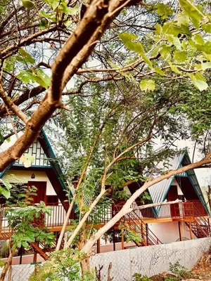 a building with a balcony in the midst of trees at Greene Villa in Palakkad