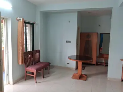 a room with a table and two chairs and a table at Vinayaka Deluxe Lodge in Kushālnagar