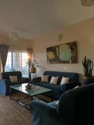 a living room with blue couches and a table at Sunset Villa in Coonoor