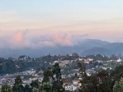 a view of a city with clouds in the background at Sunset Villa in Coonoor