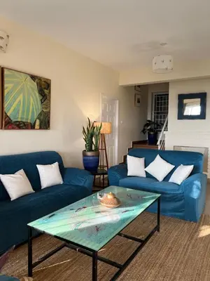 a living room with blue couches and a glass table at Sunset Villa in Coonoor
