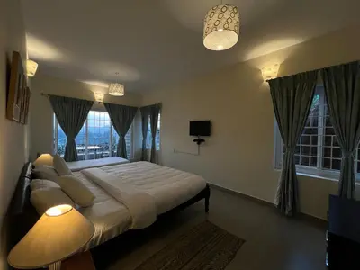 a bedroom with a large bed and a window at Sunset Villa in Coonoor