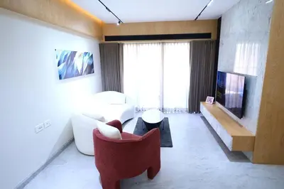 a living room with a red chair and a couch at The Nova Heights in Kozhikode