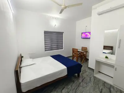 a bedroom with a bed and a dining room at Avian Oasis Homestay in Thattakād