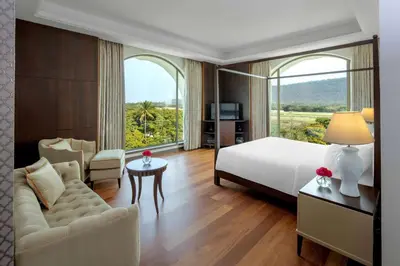 a hotel room with a bed and a couch and a window at Radisson Blu Plaza Hotel Mysore in Mysore