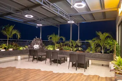 a room with a table and chairs and plants at Bumblebee - The Penthouse in Mysore