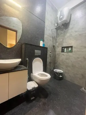 a bathroom with a toilet and a sink and a mirror at Bumblebee - The Penthouse in Mysore