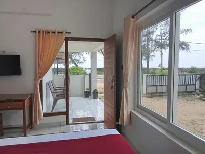 a bedroom with a bed and a sliding glass door at Appu's Nido in Pallipuram