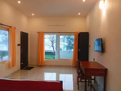 a living room with a table and a window at Appu's Nido in Pallipuram